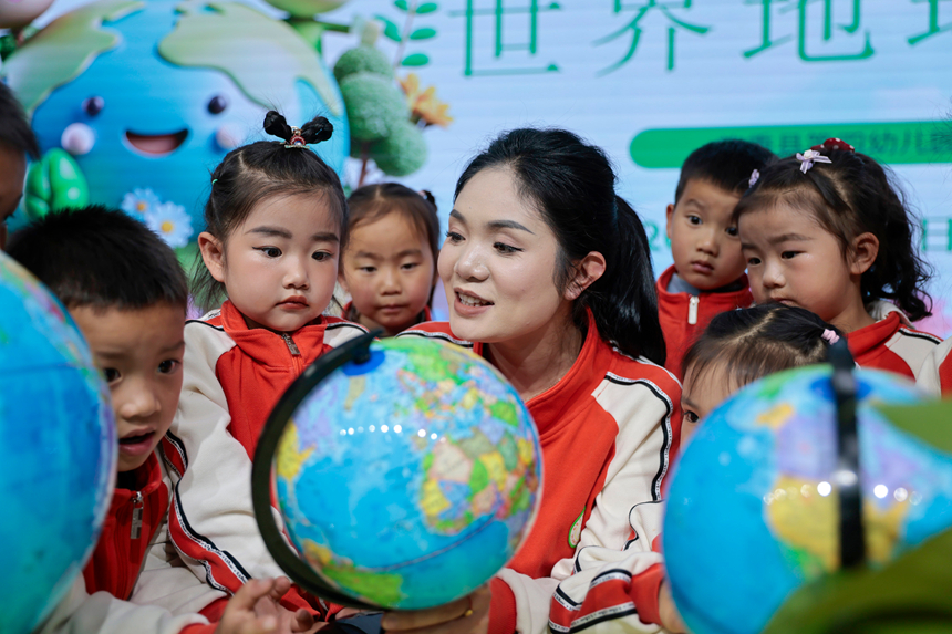 在贵州省黔东南苗族侗族自治州施秉县第四幼儿园，老师指导孩子们认识地球仪。