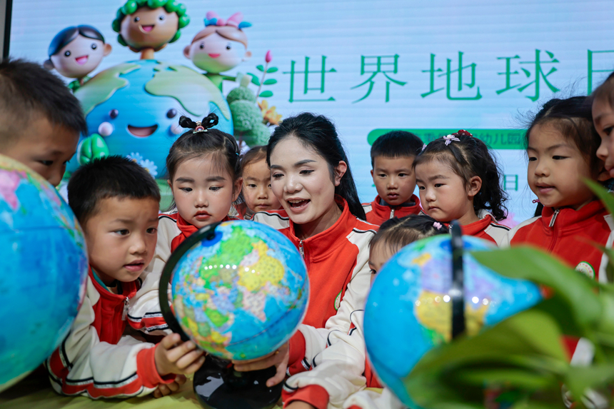 在贵州省黔东南苗族侗族自治州施秉县第四幼儿园，老师指导孩子们认识地球仪。