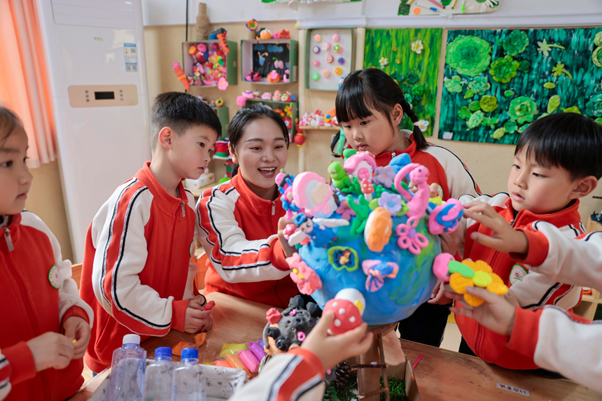 在贵州省黔东南苗族侗族自治州施秉县第四幼儿园，老师指导孩子们制作地球手工作品。