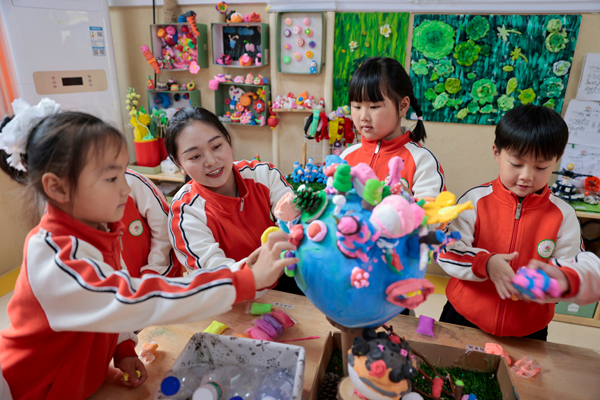 在贵州省黔东南苗族侗族自治州施秉县第四幼儿园，老师指导孩子们制作地球手工作品。