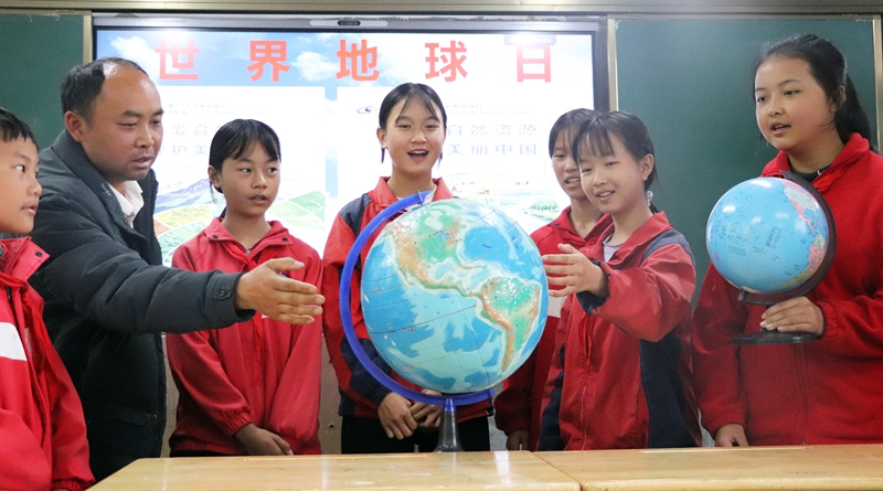 老师正通过地球仪给学生们讲解地球科学知识。 