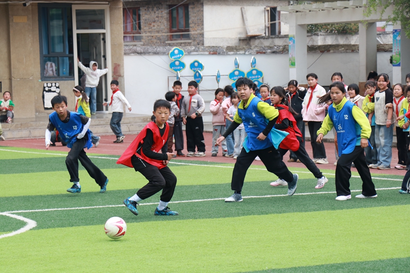 八寨中心校少年们在足球场踢球 王月 摄1.JPG