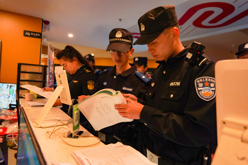 公安民警和文化市场执法人员对娱乐场所证照和人员登记进行检查。
