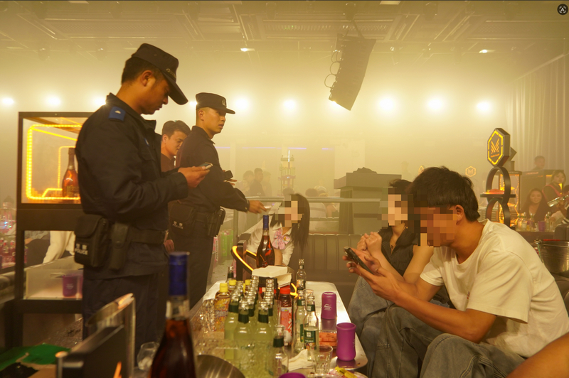 公安民警在酒吧对娱乐人员的身份信息进行核验。