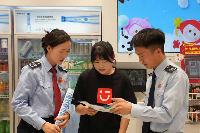 圖為 稅務干部在商圈向商戶講解稅收優惠政策。陶冶攝