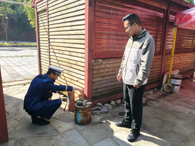 消防监督员对景区商铺灭火器进行检查.jpg