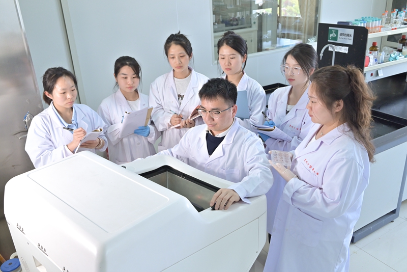 张进强（中）指导学生做组织冰冻切片。贵州中医药大学供图