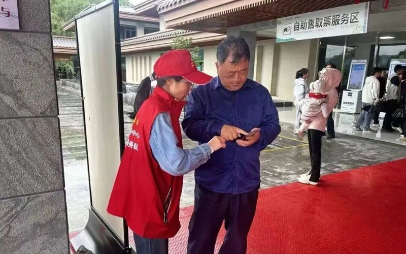 志願者身著紅馬甲遍布景區,指引游客購票。.jpg