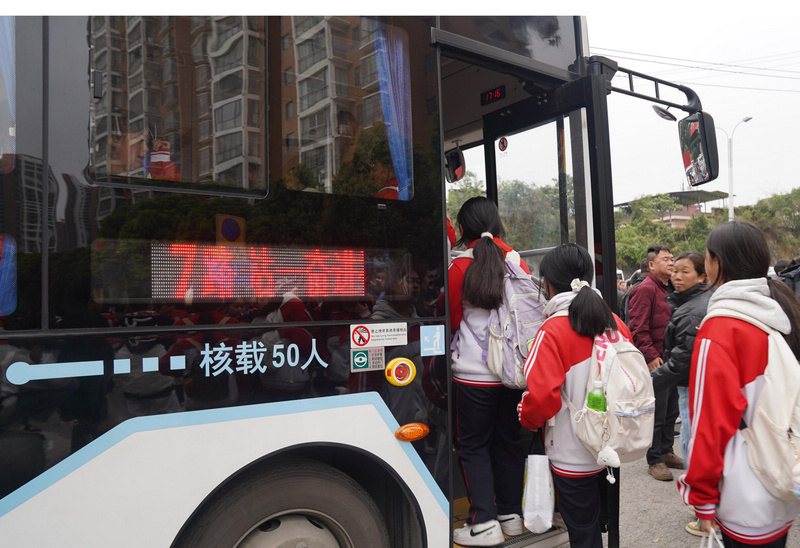  学生们有序排队上车。