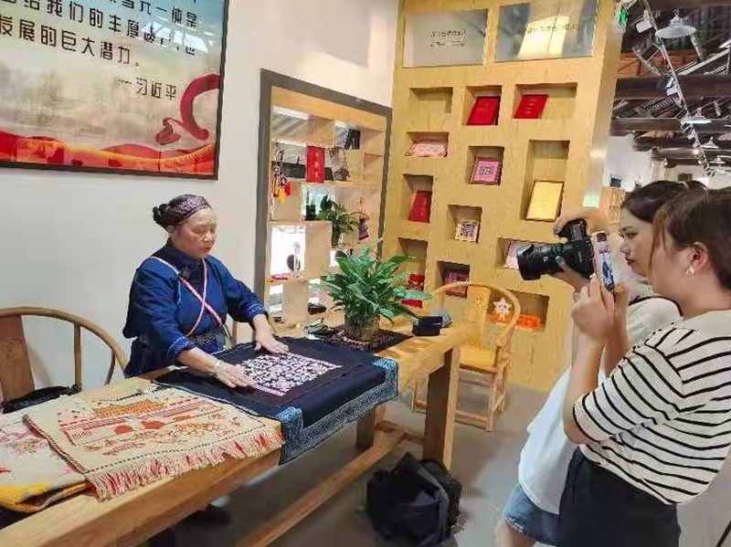 國家級代表性傳承人王啟萍展示“花溪苗繡”作品