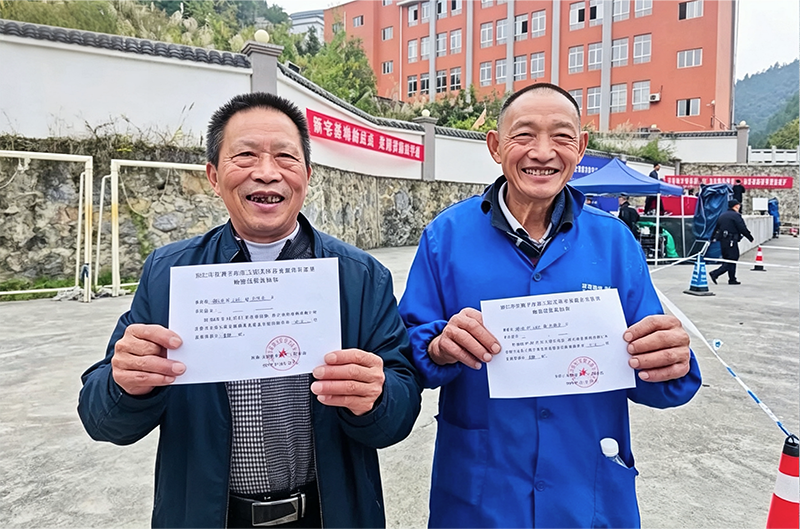 花滩子水库移民天桥安置点宅基地分配仪式上，两位移民群众十分开心地展示领到的宅基地分配确认凭证。