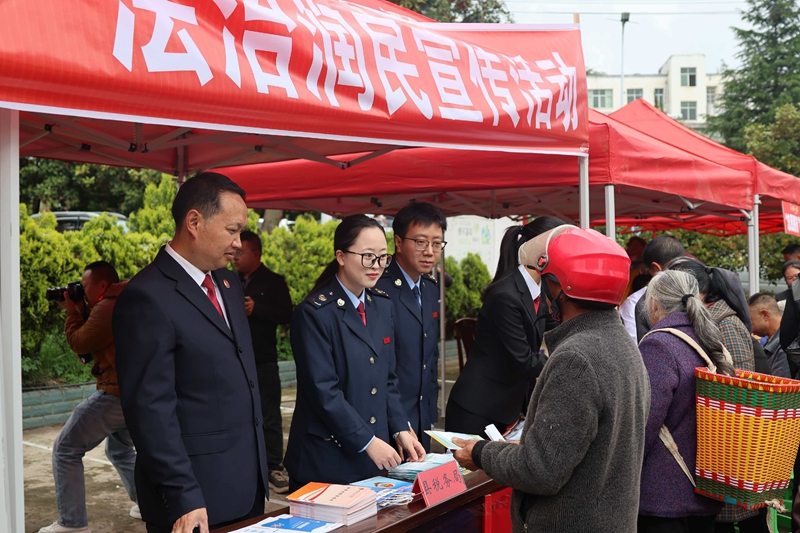 赫章縣稅務局在平山鎮鄉場活動現場,稅務干部為趕集群眾講解城鄉居民社保繳費、數電發票開具等高頻業務操作,手把手輔導群眾使用手機辦理涉稅事項,將《民法典》與稅費政策知識送到群眾家門口。.jpg