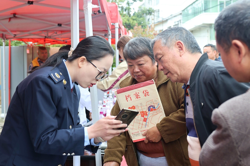 赫章縣稅務局在平山鎮鄉場活動現場,稅務干部為趕集群眾講解城鄉居民社保繳費、數電發票開具等高頻業務操作,手把手輔導群眾使用手機辦理涉稅事項。.jpg