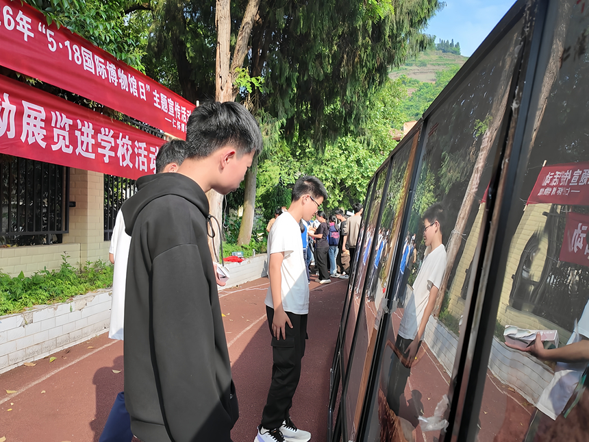 仁怀市第三中学的同学们在文物图片展板前了解文物知识。