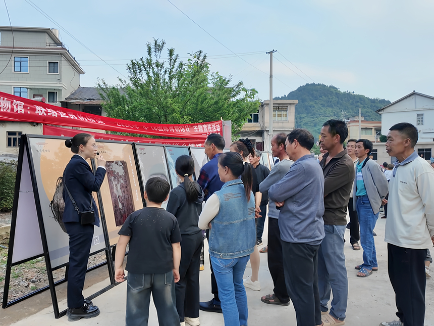 在三合镇新农村,村民们围在展板前,仔细端详文物的造型与纹饰。