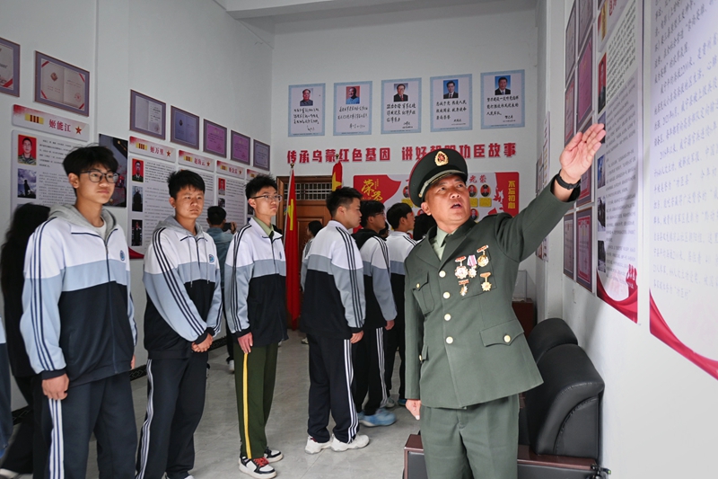 “威宁高原兵国防教育宣传员”姬正龙正在为学生讲述“功臣村”的功臣事迹。凌方艺摄.jpg