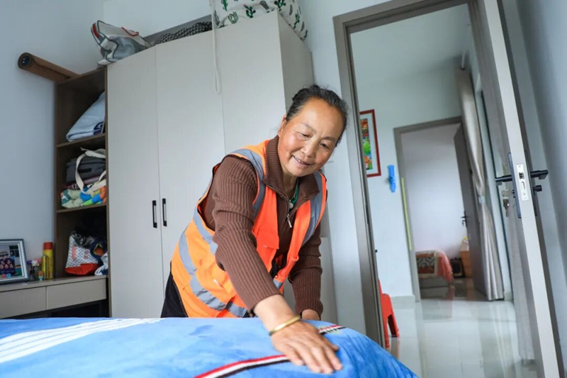 2、环卫工人张龙贤晨起整理床铺，生活安稳舒心。