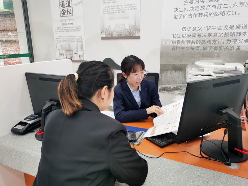 邮储银行客户经理给企业经办人员介绍跨境金融服务产品。
