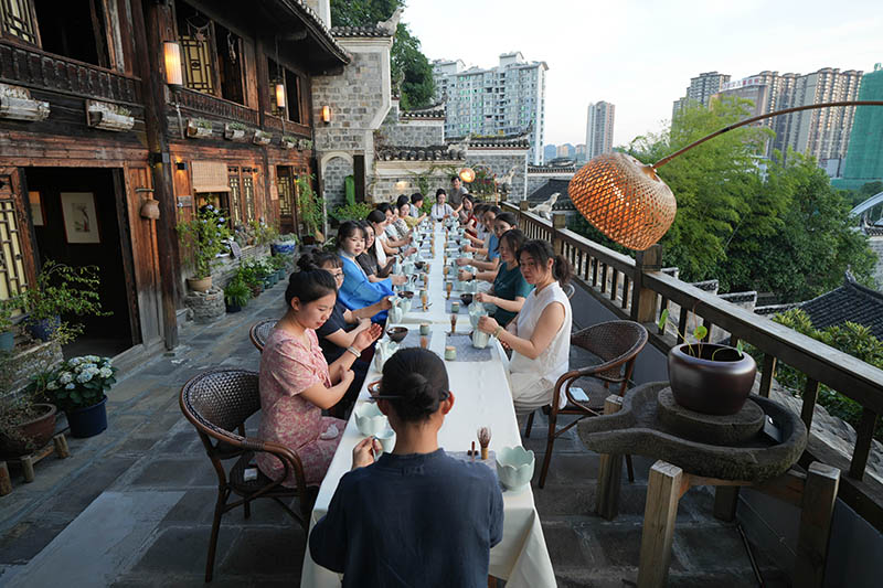 5图2025年8月28日傍晚，七夕之际，贵州省铜仁市碧江区中南门历史文化旅游区古城记忆茶舍，青年们正在体验宋代点茶。