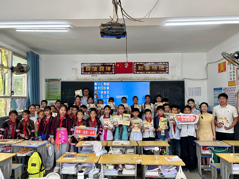 2 全体税务干部与巨洞村小学师生在教室讲台前合影留念。