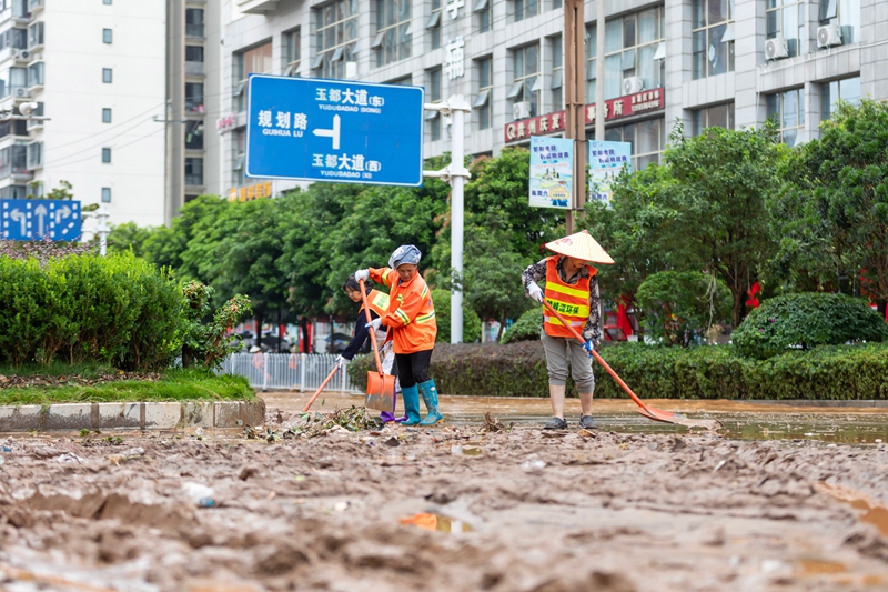 6月4日，環衛工人在貴州省黔南布依族苗族自治州羅甸縣城區清理淤泥。