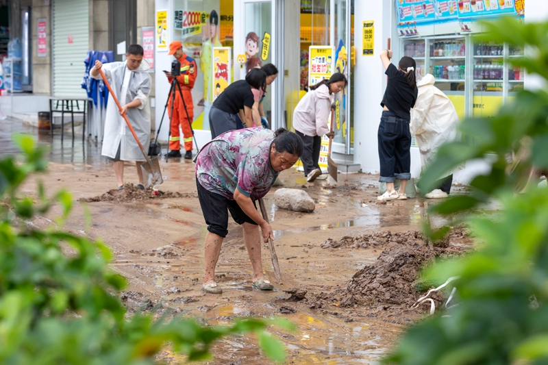 6月4日，干部和群眾在貴州省黔南布依族苗族自治州羅甸縣城區清理淤泥。