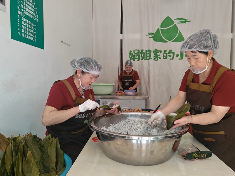 传承人王凤群与员工在包粽子.jpg