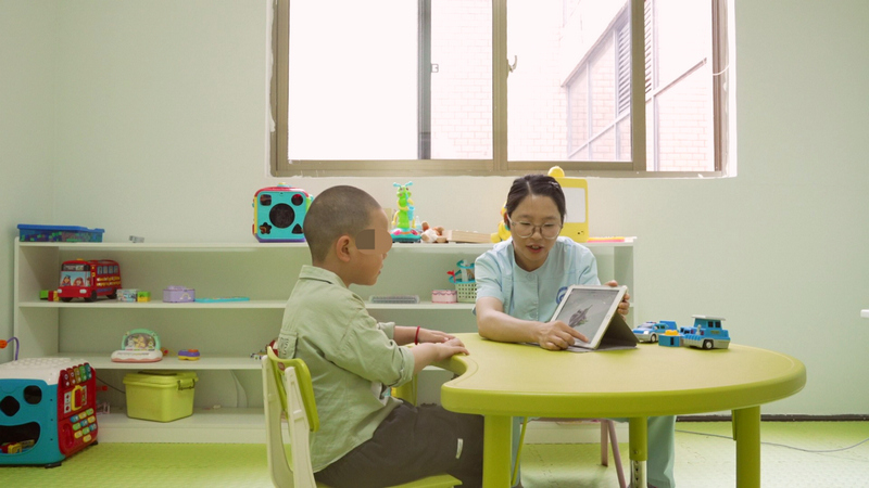 兒童康復治療師正在對孤獨症兒童進行數字化評估。