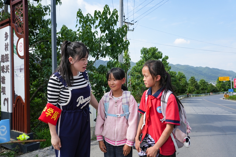 2026年6月4日，贵州省毕节市纳雍县乐治镇塘坝社区塘坝社区卢家半坡岔路口，护学老师叮嘱学生路上注意安全。 杨英 摄.jpg