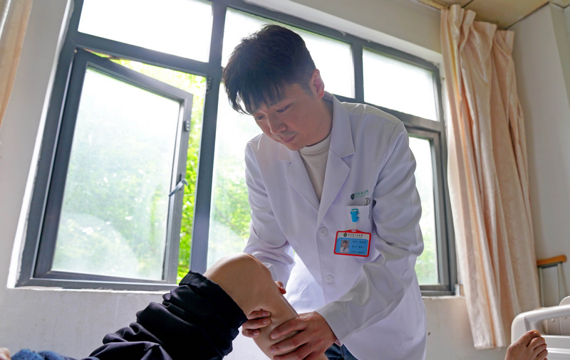贵州省人民医院骨科主治医师李彦坤正在检查病人病情。、