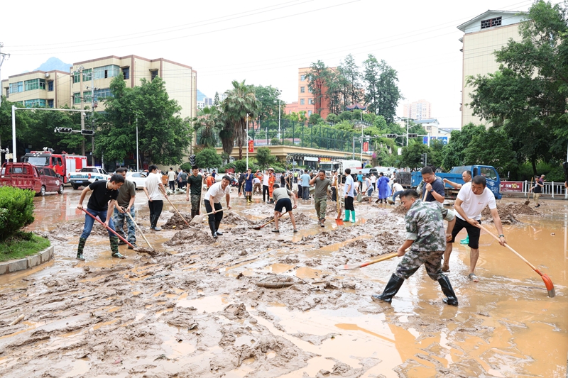 党员干部在县一小路段清理积水和淤泥.jpg