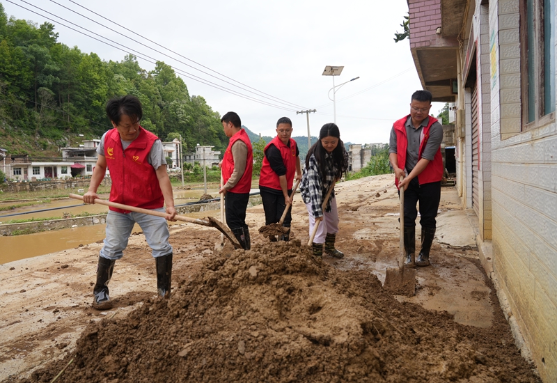 志愿者为长高村群众清理道路淤泥.JPG