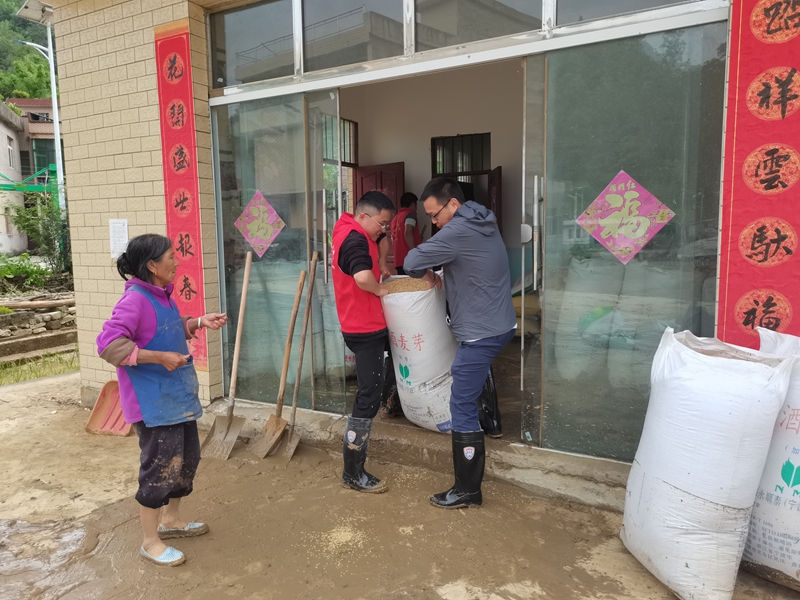 志愿者为受灾群众搬运粮食.jpg