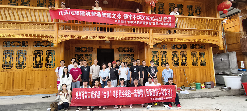 在木楼民居下合影留念.