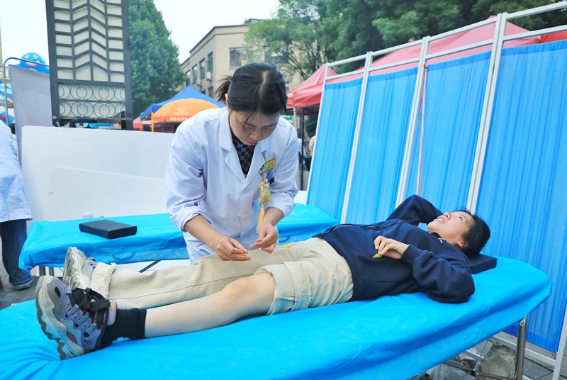 4 义诊现场，中医师根据居民身体情况开展针灸等特色中医理疗服务。
