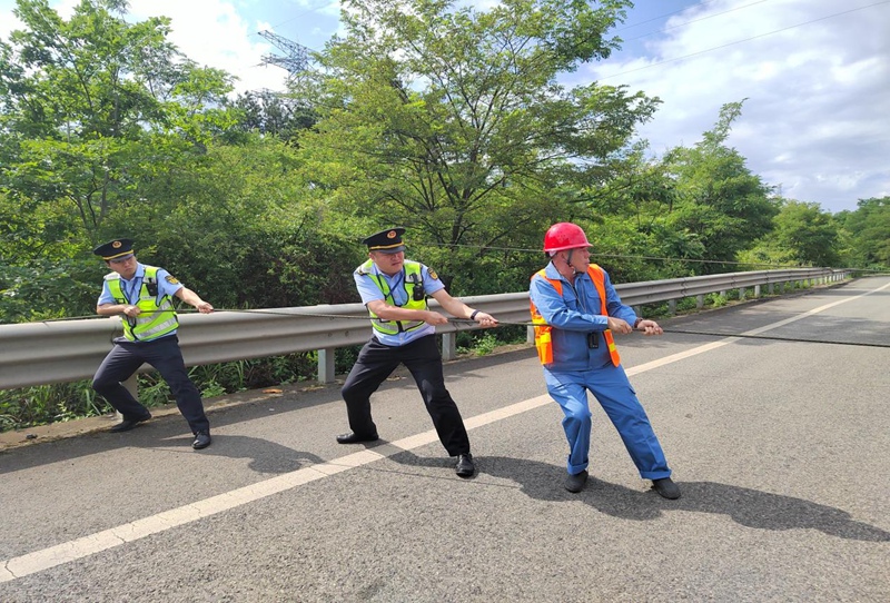 5 图为邱癸淞协助电力部门清理废弃线路