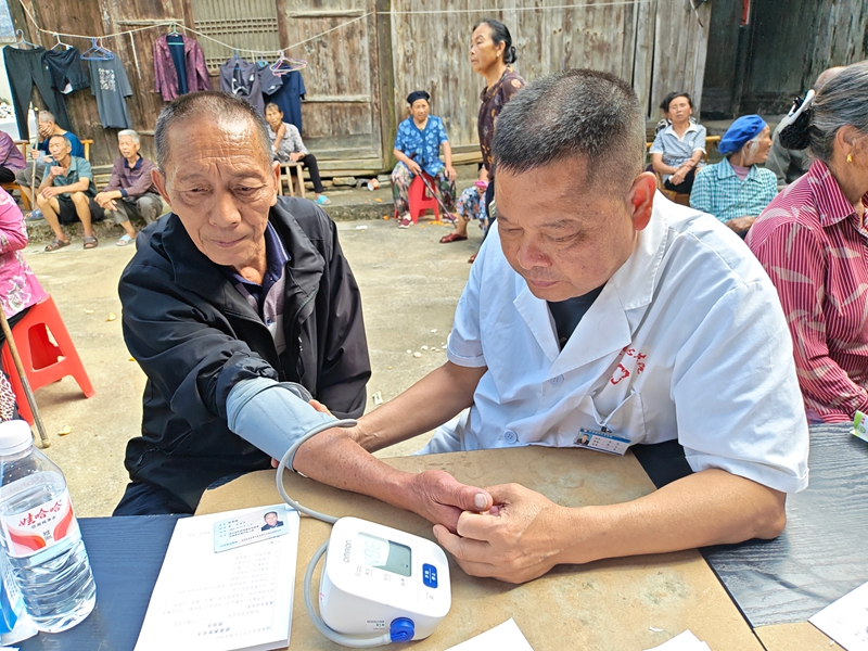 松桃普觉端午送医进村寨，医务人员正在给村民测血压.jpg