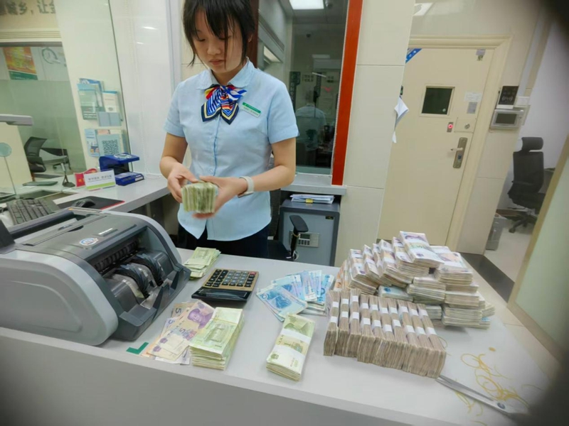 邮储银行员工正在为客户清点零钱。