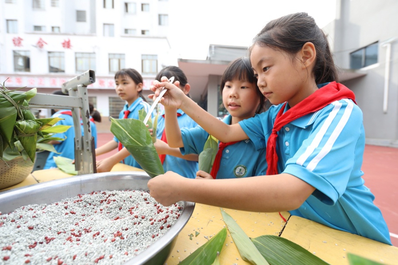 3.贵州省岑巩县第五小学，学生在学包粽子。（唐鹏 摄）
