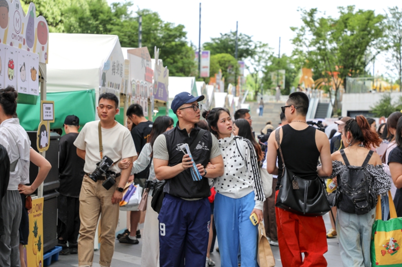 市民在集市里逛吃打卡。