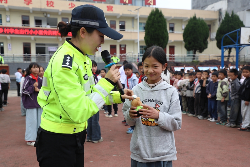 撒拉溪镇中心校受聘仪式现场 交警赠送玩偶“交警小熊”。 邱梦如 摄.JPG