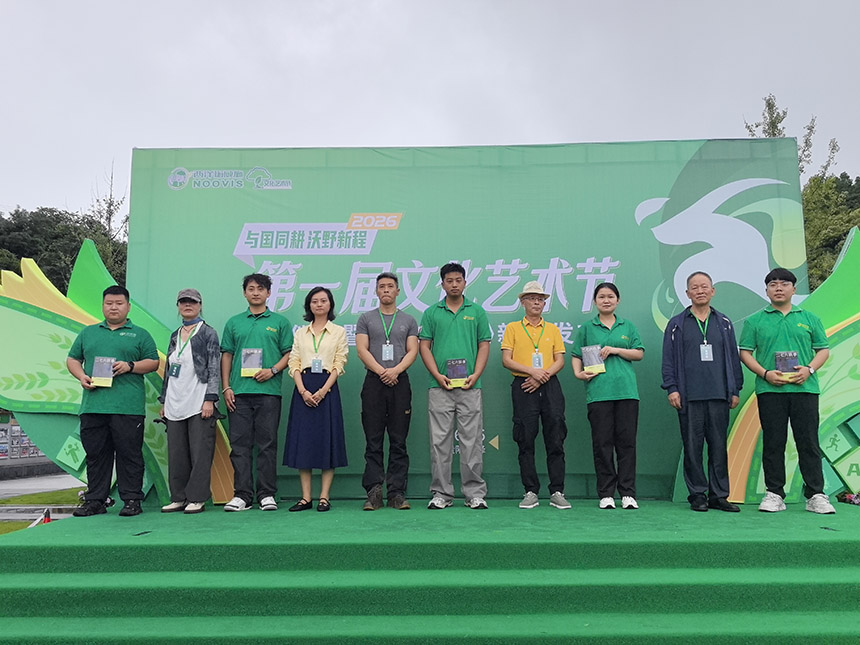 老员工向青年员工传递新书并寄语。