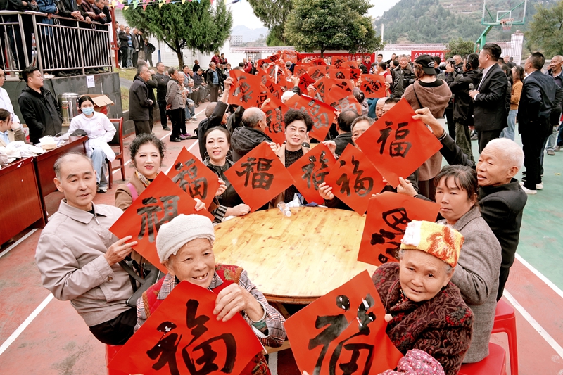 5、群众手持红彤彤的福字合影留念，喜庆的红福衬着村民一张张笑脸，既烘托热闹祥和的活动氛围，也寄托着群众对和美乡村、文明新生活的美好期盼。.jpg