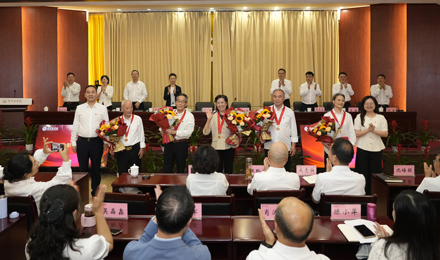 3汤健和肖小虹为老同志颁发“光荣在党50年”纪念章。