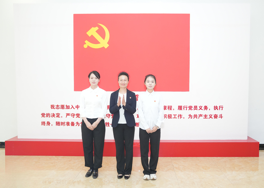 蒋云丽为新党员佩戴党员徽章。