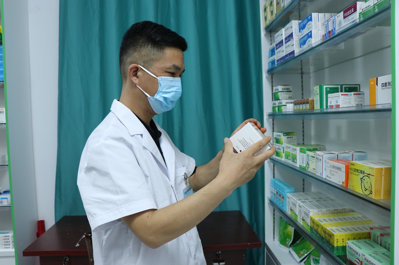 西冲社区卫生员为周边群众拿药。刘娟摄