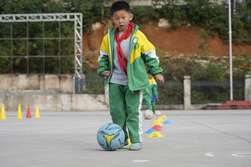 在松桃县第六小学足球社团，小朋友们练习带球过人。