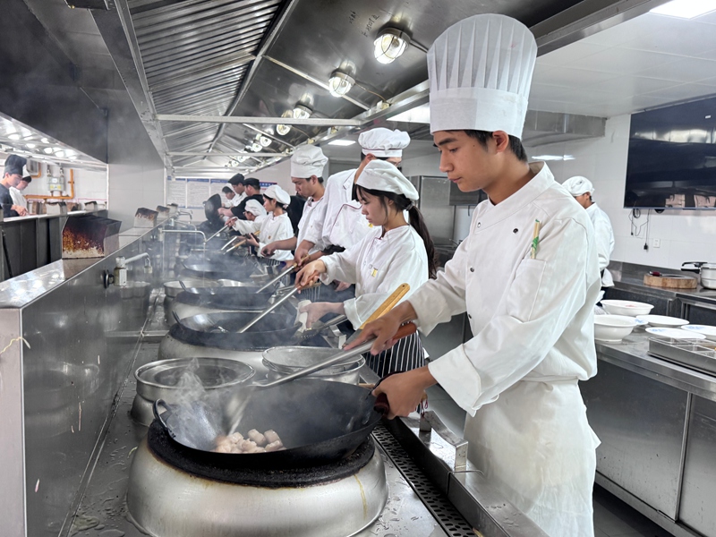 5、仁怀市中等职业学校烹饪室 学生们学习烹饪美食。