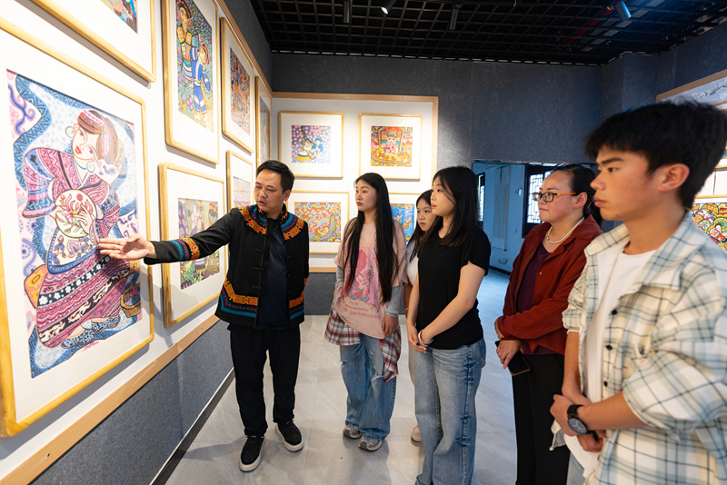 7刘华（左一）向学员介绍作品。