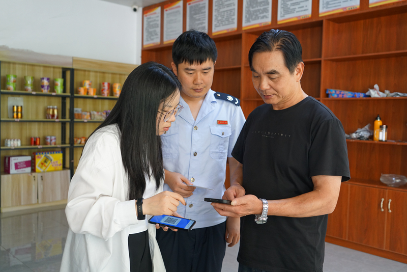 图1 为黄平县税务局干部在加油站推广“交易即开票”。杨烟摄